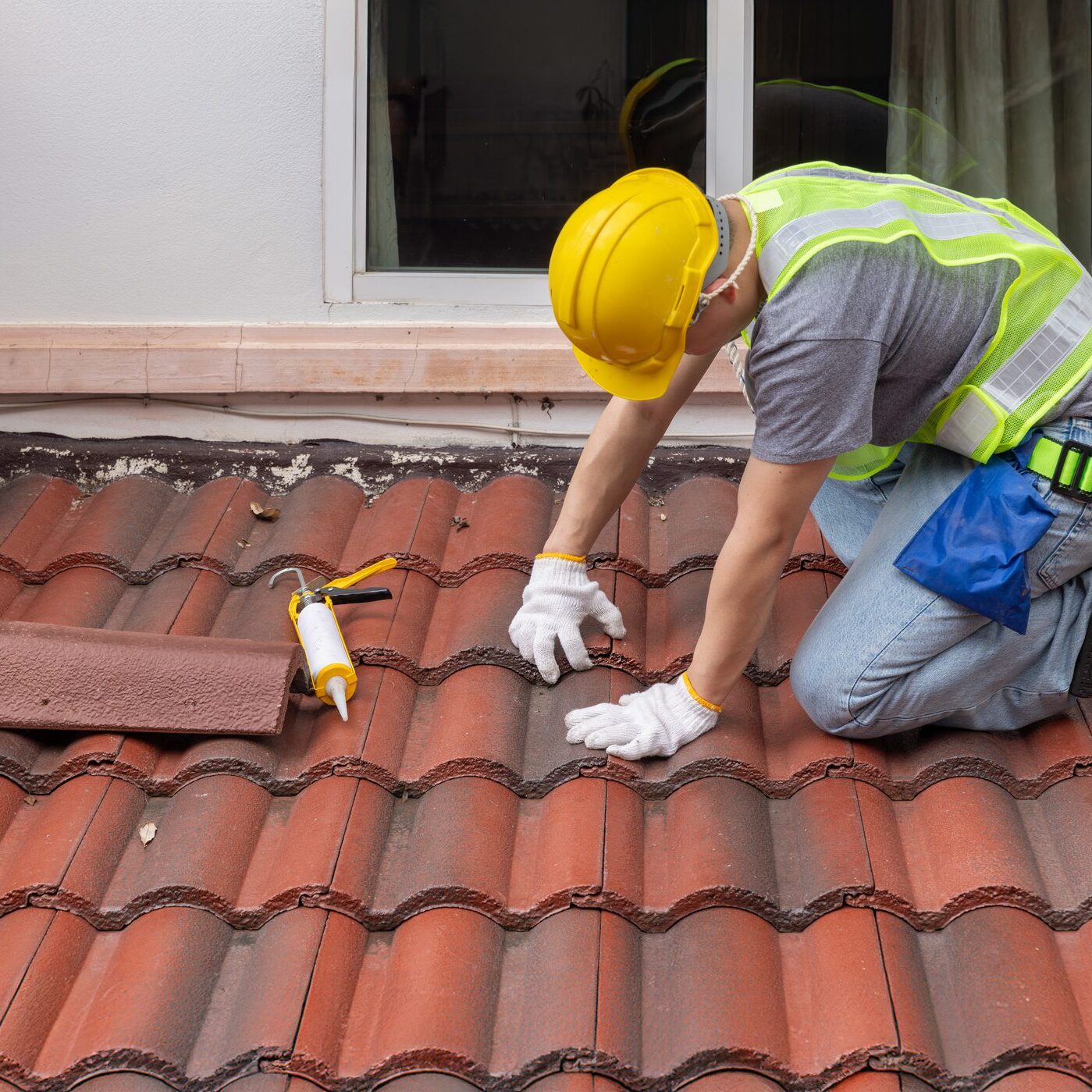 Construction worker is inspecting roof tile cracked.